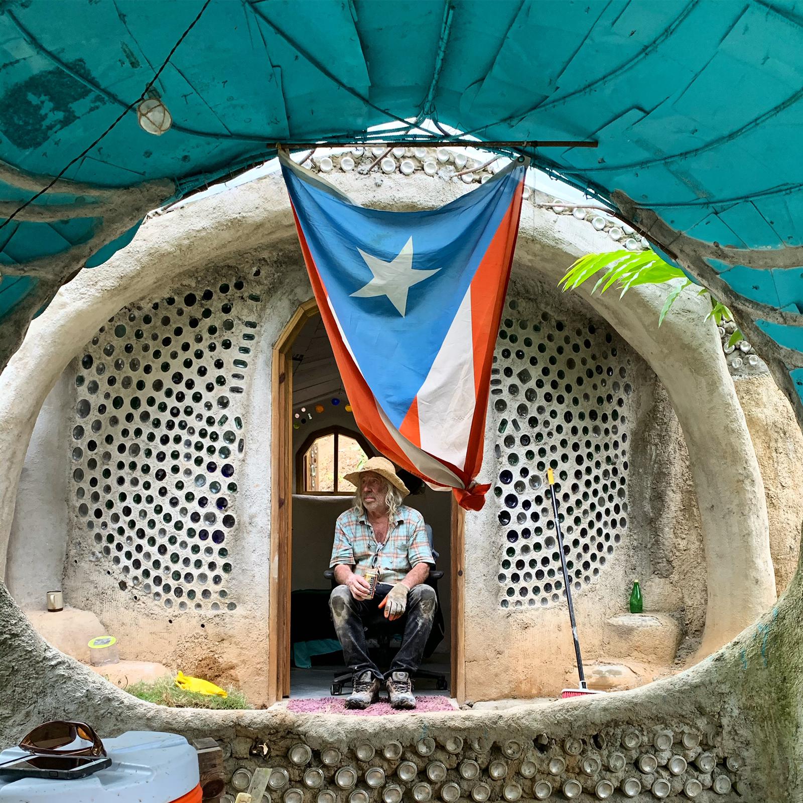 Michael Reynolds sits inside an earthship - an off-grid home made entirely from recycled materials.